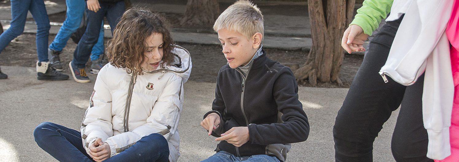 Une enfant anglais et une enfant française en pleine conversation dans la cour de l'école Greenfield